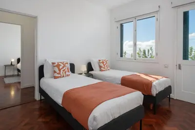 two beds in a room with two windows at Casa da Anoneira House with Pool and Sea View in Funchal