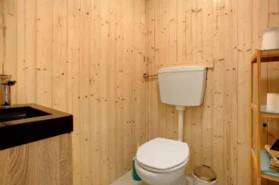 a wooden bathroom with a toilet and a sink at Sunset Cliffs By Slice Of Heaven in Ribeira Brava