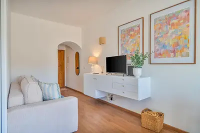a kitchen and a living room with a blue couch at Tenório Beach Apartment in Lagos