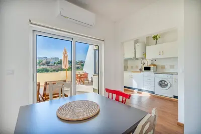 a kitchen and dining room with a table with a view at Tenório Beach Apartment in Lagos