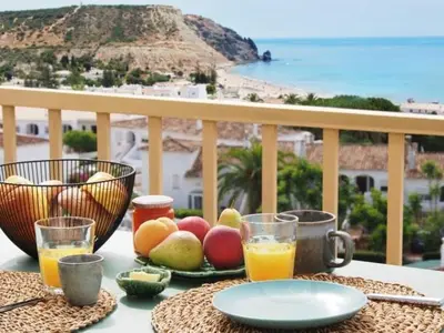a table with fruit and juice on a balcony at Breathtaking ocean views in Praia da Luz #1992 in Luz