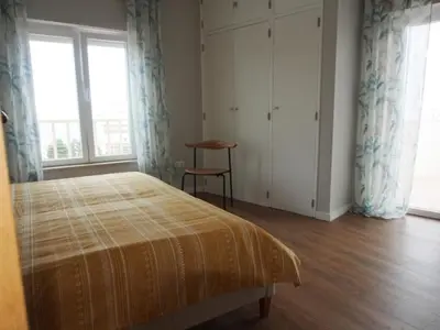 a bedroom with a bed and a chair and windows at Breathtaking ocean views in Praia da Luz #1992 in Luz