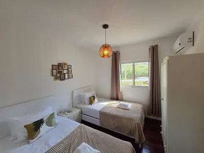 a white bedroom with a bed with a tray with flowers on it at Casa Alice by Escape to Madeira in Ponta do Pargo