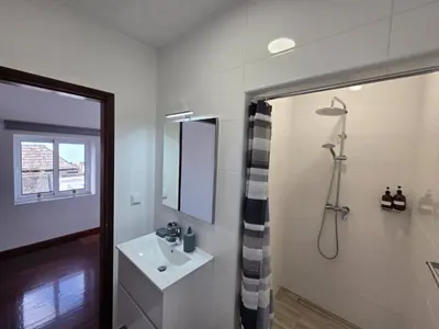 a living room with a table and a kitchen at Casa Alice by Escape to Madeira in Ponta do Pargo