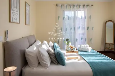 a bedroom with a bed and a couch and a window at Faias House by Escape to Madeira in Ribeira do Raposo