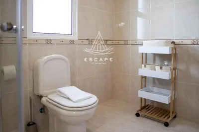 a bathroom with a toilet and a towel rack at Faias House by Escape to Madeira in Ribeira do Raposo
