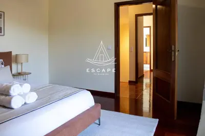 a bedroom with a bed with a sign on the wall at Faias House by Escape to Madeira in Ribeira do Raposo