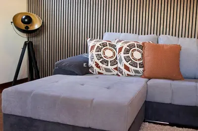 a couch with pillows on it in a living room at Faias House by Escape to Madeira in Ribeira do Raposo