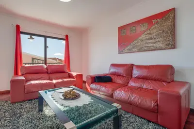 a living room with a red couch and a table at Andrade's Villa by Holiday Rental Madeira in Caniço