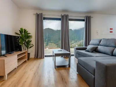 a living room with a couch and a large window at The Village View I, By OP in São Vicente