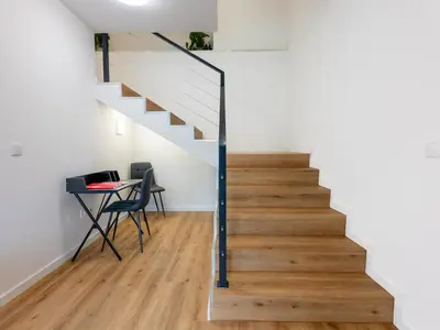 a staircase in a room with a table and a stair case at The Village View I, By OP in São Vicente