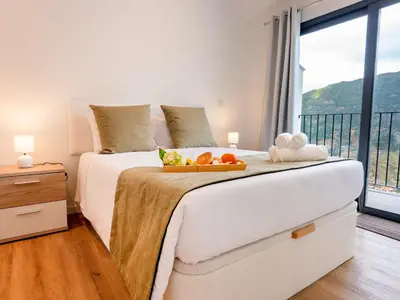 a bedroom with a bed with a tray of fruit on it at The Village View I, By OP in São Vicente