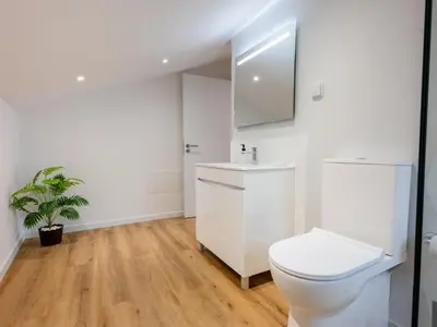 a white bathroom with a toilet and a sink at The Village View I, By OP in São Vicente