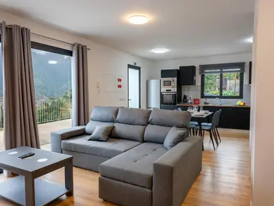 a living room with a couch and a kitchen at The Village View I, By OP in São Vicente