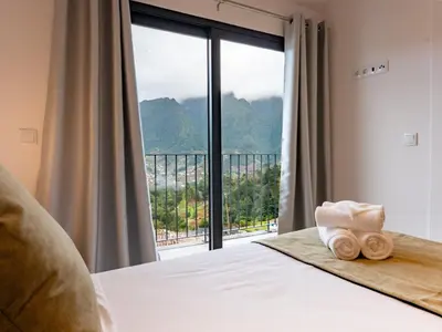 a living room with a couch and a large window at The Village View I, By OP in São Vicente