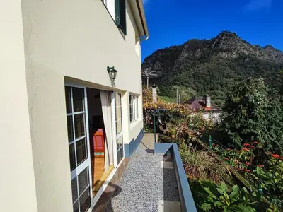 a house with a pathway leading to a door with a mountain in the background at Madeira V2 Porto da Cruz in Porto da Cruz