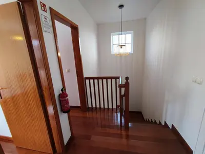 a hallway with a stairway with a door and a window at Madeira V2 Porto da Cruz in Porto da Cruz