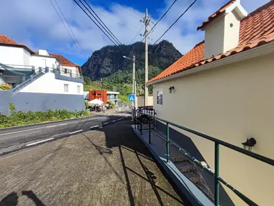 an empty street with buildings and mountains in the background at Madeira V2 Porto da Cruz in Porto da Cruz