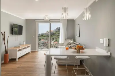 a kitchen with a table and chairs and a living room at Casas ao Sol by An Island Apart in Ponta do Sol