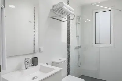 a white bathroom with a shower and a sink at Casas ao Sol by An Island Apart in Ponta do Sol