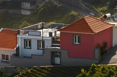 a group of houses with red roofs on a hill at Casas ao Sol by An Island Apart in Ponta do Sol