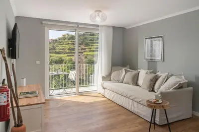 a living room with a couch and a large window at Casas ao Sol by An Island Apart in Ponta do Sol
