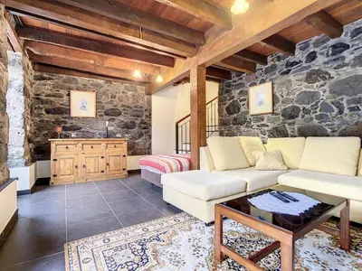 a living room with a stone wall at Villa Bella Vista by AH in São Vicente