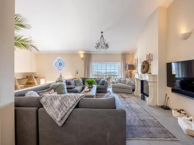 a living room with a couch and a tv at Private Bedroom in a Luxurious Villa, Budens in Budens