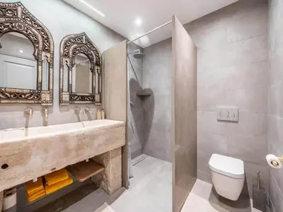 a bathroom with a sink and a toilet and a mirror at Private Bedroom in a Luxurious Villa, Budens in Budens