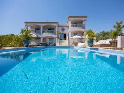 a large swimming pool in front of a house at Private Bedroom in a Luxurious Villa, Budens in Budens