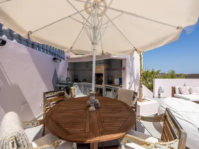 a wooden table with an umbrella on a patio at Nice Villa in Budens with pool in Budens