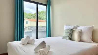 a bedroom with a large white bed with a window at Vista Pena in Funchal
