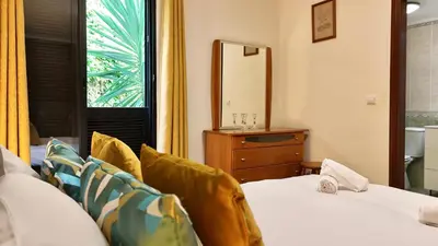 a bedroom with two beds and a mirror and a window at Vista Pena in Funchal