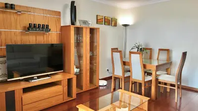 a living room with a television and a table with chairs at Vista Pena in Funchal