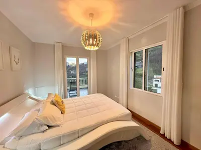 a bedroom with a large bed and a chandelier at Vista Verde in Estreito de Câmara de Lobos