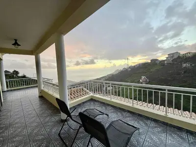 a balcony with two chairs and a view of the ocean at Vista Verde in Estreito de Câmara de Lobos