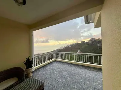 a room with a balcony with a view of the ocean at Vista Verde in Estreito de Câmara de Lobos