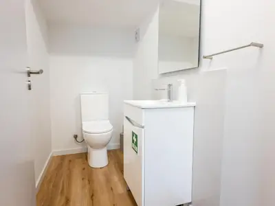 a white bathroom with a toilet and a sink at The Village View II, By OP in São Vicente