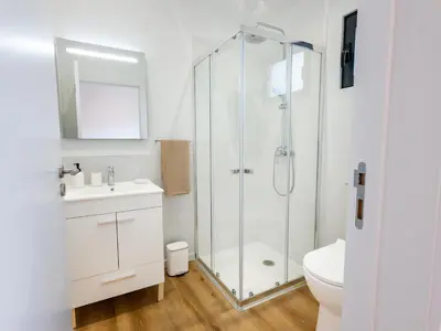a white bathroom with a shower and a sink at The Village View II, By OP in São Vicente