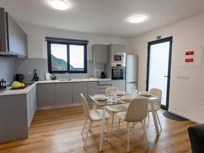 a kitchen and dining room with a table and chairs at The Village View II, By OP in São Vicente