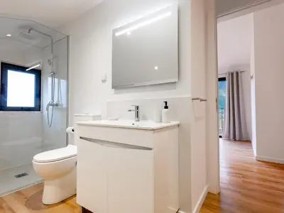 a white bathroom with a toilet and a sink at The Village View II, By OP in São Vicente