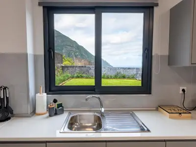 a kitchen with a sink and a window at The Village View II, By OP in São Vicente