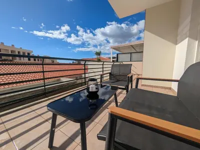 a balcony with a table and chairs on a roof at Pátio do Garajau in Caniço