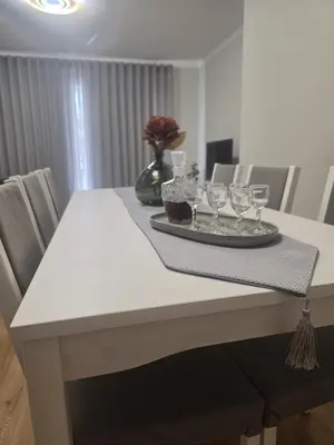 a dining room table with a plate and glasses on it at Pátio do Garajau in Caniço