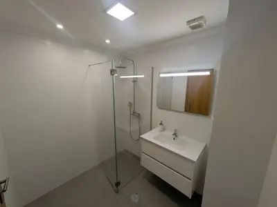 a bathroom with a shower and a sink and a mirror at Pátio do Garajau in Caniço