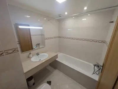 a bathroom with a sink and a tub and a toilet at Pátio do Garajau in Caniço