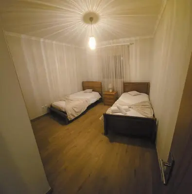 two beds in a small room with a ceiling at Pátio do Garajau in Caniço