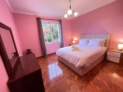 a pink bedroom with a bed and a window at Forest View Countryside in Serra de Água