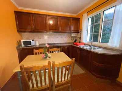 a kitchen with a table with chairs and a microwave at Forest View Countryside in Serra de Água