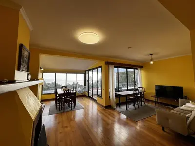 a dining room with a table and chairs and a large window at Machico View in Machico